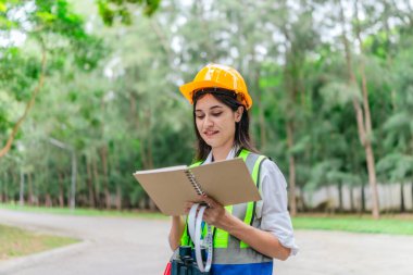 Dişi çevre araştırmacısı orman koşullarını dürbün kullanarak gözlemliyor, not alıyor, veri iletiyor. Çevresel izleme, biyolojik çeşitlilik takibi, kadınların dosyalanmış orman değerlendirmelerindeki rolü.