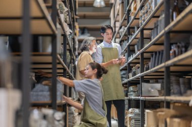 Anne ve sahibi çocuklarını aile işletmeleri deposunda yetiştiriyor. Malzeme seçimi, ürün kalitesi, üretim verimliliğini ve çevre dostu faaliyetleri artırmak için sürdürülebilir geri dönüşüm uygulamaları