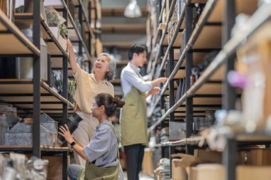 Anne ve sahibi çocuklarını aile işletmeleri deposunda yetiştiriyor. Malzeme seçimi, ürün kalitesi, üretim verimliliğini ve çevre dostu faaliyetleri artırmak için sürdürülebilir geri dönüşüm uygulamaları