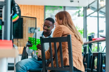 İki ürün tasarımcısı tasarım stüdyosunda 3 boyutlu prototipleri inceleyip tartışıyor. Ürün geliştirmede katkı sağlayan üretim teknolojisi kullanılarak takım çalışmasını, yaratıcılığı ve uygulamalı testleri vurgulamak