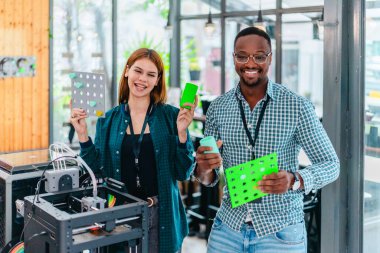 İki ürün tasarımcısı tasarım stüdyosunda 3 boyutlu prototipleri inceleyip tartışıyor. Ürün geliştirmede katkı sağlayan üretim teknolojisi kullanılarak takım çalışmasını, yaratıcılığı ve uygulamalı testleri vurgulamak