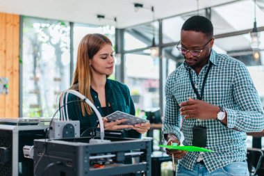 İki ürün tasarımcısı tasarım stüdyosunda 3 boyutlu prototipleri inceleyip tartışıyor. Ürün geliştirmede katkı sağlayan üretim teknolojisi kullanılarak takım çalışmasını, yaratıcılığı ve uygulamalı testleri vurgulamak