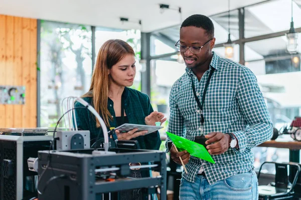 İki ürün tasarımcısı tasarım stüdyosunda 3 boyutlu prototipleri inceleyip tartışıyor. Ürün geliştirmede katkı sağlayan üretim teknolojisi kullanılarak takım çalışmasını, yaratıcılığı ve uygulamalı testleri vurgulamak