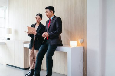 İki profesyonel odaklanmış bir beyin fırtınası oturumunda, planlama araçlarını kullanarak ve tartışarak şık, işbirlikçi bir ofis ortamında yeni fikirler geliştiriyorlar..