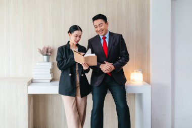 İki profesyonel odaklanmış bir beyin fırtınası oturumunda, planlama araçlarını kullanarak ve tartışarak şık, işbirlikçi bir ofis ortamında yeni fikirler geliştiriyorlar..