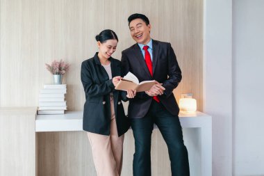 İki profesyonel odaklanmış bir beyin fırtınası oturumunda, planlama araçlarını kullanarak ve tartışarak şık, işbirlikçi bir ofis ortamında yeni fikirler geliştiriyorlar..