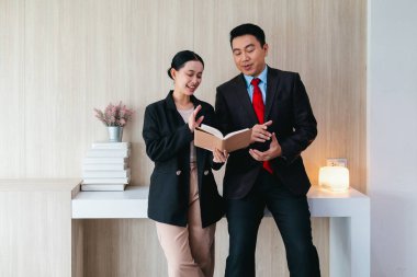 İki profesyonel odaklanmış bir beyin fırtınası oturumunda, planlama araçlarını kullanarak ve tartışarak şık, işbirlikçi bir ofis ortamında yeni fikirler geliştiriyorlar..