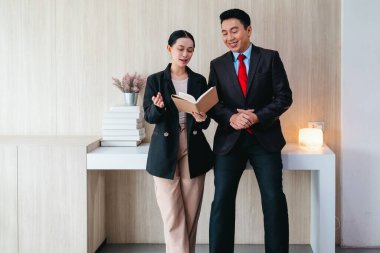 İki profesyonel odaklanmış bir beyin fırtınası oturumunda, planlama araçlarını kullanarak ve tartışarak şık, işbirlikçi bir ofis ortamında yeni fikirler geliştiriyorlar..