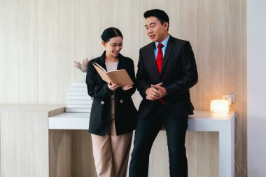 İki profesyonel odaklanmış bir beyin fırtınası oturumunda, planlama araçlarını kullanarak ve tartışarak şık, işbirlikçi bir ofis ortamında yeni fikirler geliştiriyorlar..