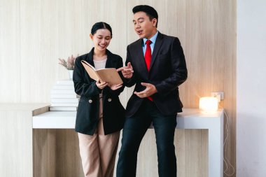 İki profesyonel odaklanmış bir beyin fırtınası oturumunda, planlama araçlarını kullanarak ve tartışarak şık, işbirlikçi bir ofis ortamında yeni fikirler geliştiriyorlar..