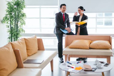 İki profesyonel odaklanmış bir beyin fırtınası oturumunda, planlama araçlarını kullanarak ve tartışarak şık, işbirlikçi bir ofis ortamında yeni fikirler geliştiriyorlar..