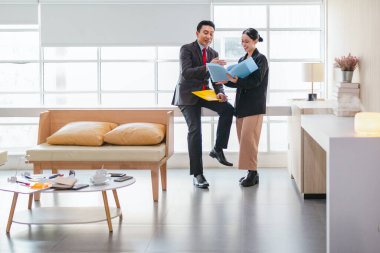 İki profesyonel odaklanmış bir beyin fırtınası oturumunda, planlama araçlarını kullanarak ve tartışarak şık, işbirlikçi bir ofis ortamında yeni fikirler geliştiriyorlar..