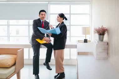 İki profesyonel odaklanmış bir beyin fırtınası oturumunda, planlama araçlarını kullanarak ve tartışarak şık, işbirlikçi bir ofis ortamında yeni fikirler geliştiriyorlar..