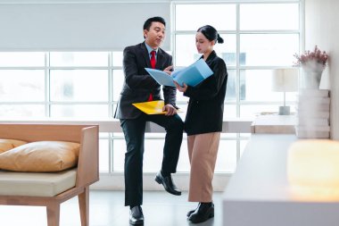 İki profesyonel odaklanmış bir beyin fırtınası oturumunda, planlama araçlarını kullanarak ve tartışarak şık, işbirlikçi bir ofis ortamında yeni fikirler geliştiriyorlar..