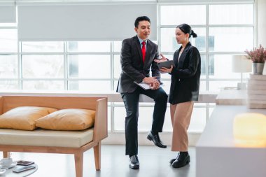 İki profesyonel odaklanmış bir beyin fırtınası oturumunda, planlama araçlarını kullanarak ve tartışarak şık, işbirlikçi bir ofis ortamında yeni fikirler geliştiriyorlar..