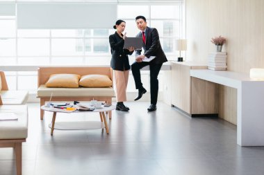 İki profesyonel odaklanmış bir beyin fırtınası oturumunda, planlama araçlarını kullanarak ve tartışarak şık, işbirlikçi bir ofis ortamında yeni fikirler geliştiriyorlar..