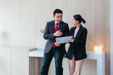 İki profesyonel odaklanmış bir beyin fırtınası oturumunda, planlama araçlarını kullanarak ve tartışarak şık, işbirlikçi bir ofis ortamında yeni fikirler geliştiriyorlar..