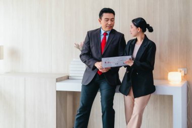 İki profesyonel odaklanmış bir beyin fırtınası oturumunda, planlama araçlarını kullanarak ve tartışarak şık, işbirlikçi bir ofis ortamında yeni fikirler geliştiriyorlar..