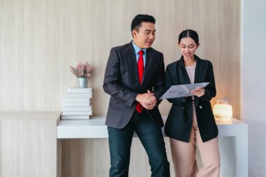 İki profesyonel odaklanmış bir beyin fırtınası oturumunda, planlama araçlarını kullanarak ve tartışarak şık, işbirlikçi bir ofis ortamında yeni fikirler geliştiriyorlar..