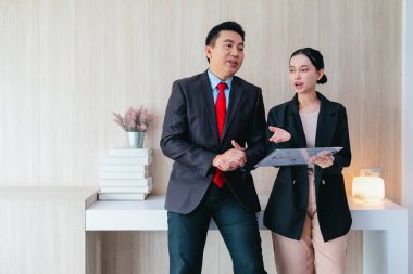 İki profesyonel odaklanmış bir beyin fırtınası oturumunda, planlama araçlarını kullanarak ve tartışarak şık, işbirlikçi bir ofis ortamında yeni fikirler geliştiriyorlar..