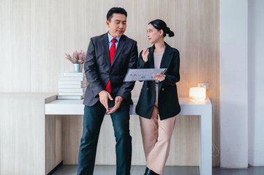 İki profesyonel odaklanmış bir beyin fırtınası oturumunda, planlama araçlarını kullanarak ve tartışarak şık, işbirlikçi bir ofis ortamında yeni fikirler geliştiriyorlar..