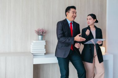 İki profesyonel odaklanmış bir beyin fırtınası oturumunda, planlama araçlarını kullanarak ve tartışarak şık, işbirlikçi bir ofis ortamında yeni fikirler geliştiriyorlar..