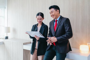 İki profesyonel odaklanmış bir beyin fırtınası oturumunda, planlama araçlarını kullanarak ve tartışarak şık, işbirlikçi bir ofis ortamında yeni fikirler geliştiriyorlar..