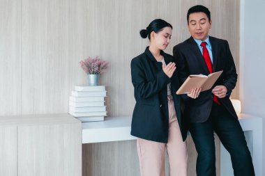 İki profesyonel odaklanmış bir beyin fırtınası oturumunda, planlama araçlarını kullanarak ve tartışarak şık, işbirlikçi bir ofis ortamında yeni fikirler geliştiriyorlar..