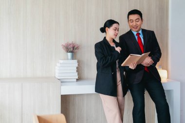 İki profesyonel odaklanmış bir beyin fırtınası oturumunda, planlama araçlarını kullanarak ve tartışarak şık, işbirlikçi bir ofis ortamında yeni fikirler geliştiriyorlar..