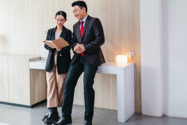 İki profesyonel odaklanmış bir beyin fırtınası oturumunda, planlama araçlarını kullanarak ve tartışarak şık, işbirlikçi bir ofis ortamında yeni fikirler geliştiriyorlar..