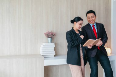 İki profesyonel odaklanmış bir beyin fırtınası oturumunda, planlama araçlarını kullanarak ve tartışarak şık, işbirlikçi bir ofis ortamında yeni fikirler geliştiriyorlar..