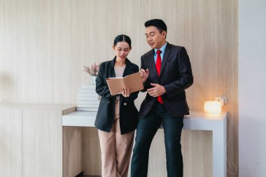 İki profesyonel odaklanmış bir beyin fırtınası oturumunda, planlama araçlarını kullanarak ve tartışarak şık, işbirlikçi bir ofis ortamında yeni fikirler geliştiriyorlar..