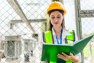 Kadın bir saha analisti pompa istasyonunda inceleme ve veri toplama yapar. Kamu hizmetleri altyapı yönetiminde teknik alan çalışması, kalite kontrolü ve karbon ayak izi denetimi.
