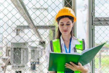 Kadın bir saha analisti pompa istasyonunda inceleme ve veri toplama yapar. Kamu hizmetleri altyapı yönetiminde teknik alan çalışması, kalite kontrolü ve karbon ayak izi denetimi.