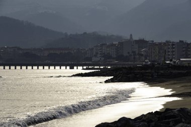 Deniz dalgaları, Ligurian kıyısındaki Spotorno sahilinde soğuk bir kış günü kırılıyor.