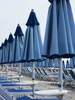 Spotorno 'nun Ligurian Rivierası' nın kumlu sahillerinde güverte sandalyeleri ve şemsiyeler.