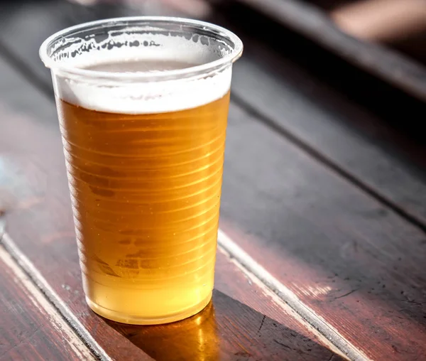 Plastic cup of ice cold beer at beer festivals like Oktoberfest celebrated in October 2025 with blurred background