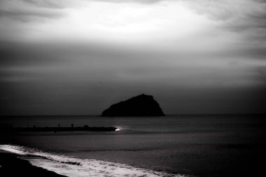 Kış denizi, dalgalar kumsalda kırılıyor ve kayalıklarda soğuk kış rüzgarı esiyor