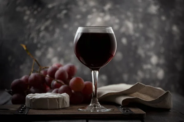 Stilleben med rött vin, vinranka, ost. — Stockfoto
