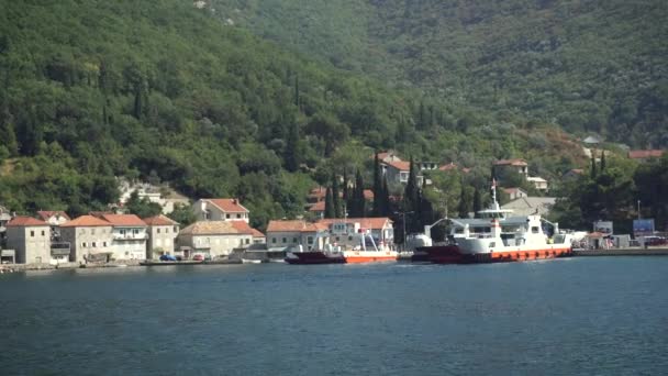 Tivat, MONTENEGRO - 3. syyskuuta: Panning shot of ferry boat transporting cars and passenger from Kamenari to Tivat 3. syyskuuta 2016 Tivat, Montenegro 4k — kuvapankkivideo