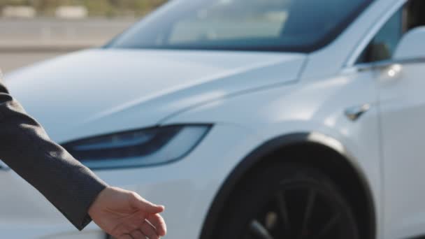 Negociante dando a chave para o novo proprietário em auto show ou salão. Mão masculina dá uma chave de carro para a mão masculina na concessionária de carro de perto. Automóvel não reconhecido vendedor e um homem que comprou um veículo apertar as mãos. — Vídeo de Stock