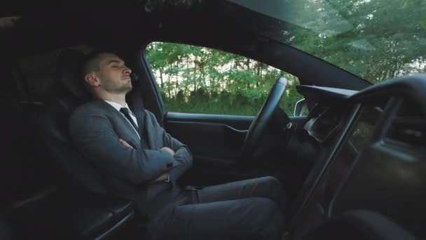 Empresário dormindo atrás do volante de auto-condução em auto-piloto autônomo carro elétrico sem motorista. Profundamente adormecido homem dirigindo ao longo da estrada rural em veículo todo-elétrico de luxo. — Vídeo de Stock
