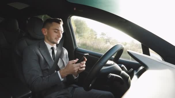 Pengalaman bisnis Kaukasia untuk mengendarai mobil pintar self-driving di jalan raya. Man Driver Menggunakan Smartphone saat duduk di dalam mobil. Orang dan media sosial. Pengemudi. Orang — Stok Video