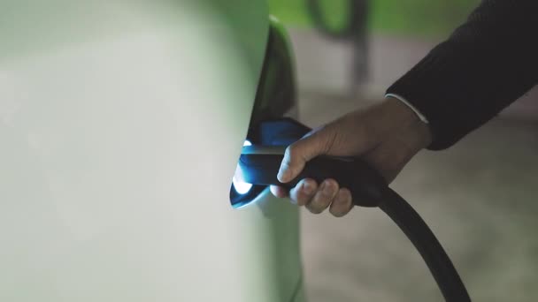 Desenchufe el conector del cable de carga del coche eléctrico. Hombre irreconocible desenchufando coche eléctrico. Llenado de energía eléctrica compiten y cable desconectado — Vídeo de stock