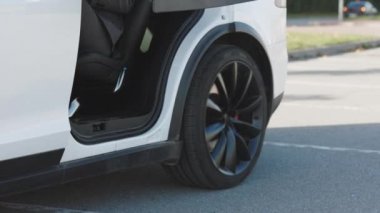 Adam araçtan iniyor. İş adamı bacakları yakın plan. Katı takım elbiseli bir adam kapıyı açar ve lüks bir arabadan iner.