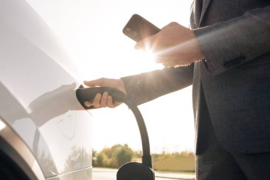 Tanımlanamayan işadamı elektrikli arabayı şarj istasyonundan çıkartıyor. Sunbae gün batımında elektrikli bir arabaya elektrik kablosu takacak. Kafkasyalı işadamı şarj istasyonunda elektrikli araba yüklüyor.