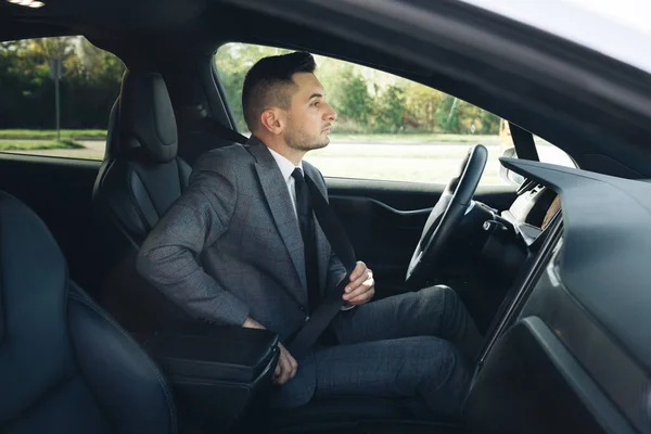 Proteção de uma pessoa em veículos. Aperte o corpo com um cinto de segurança no carro. Homem prende cinto de segurança do carro com a mão. Cumprimento das regras de segurança para a condução. Conceito de regulamentação de segurança rodoviária. — Fotografia de Stock