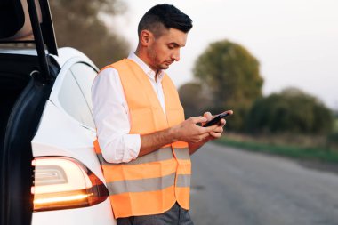 Bozuk Elektrikli Arabadaki Üzgün Adam. Araç Kontrol Hasar Kontrolü. Elektrikli araba boşalmış. Otomatik Hata Teftişi