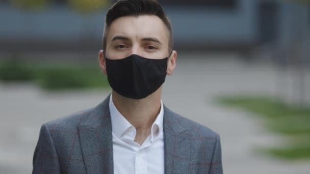 日中に街中で、大気汚染や海綿状の19コロナウイルスに対する顔のマスクを着て、原因となるアジア人の男性の肖像画 — ストック動画