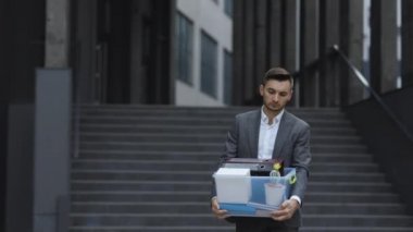 İşadamı kovuldu ve elinde kutu belgeleriyle ofis merkezine doğru yürüdü. İşini kaybetmişti. İşsizlik oranı pandemik olarak artıyor. Çaresizlik içindeki erkek ofis çalışanı işini kaybetti